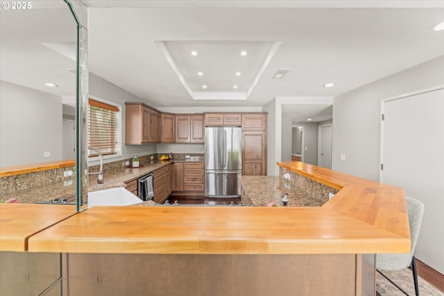 48 Eagle Crest Dr Unit 3D, Lake Oswego, OR 97035 - kitchen with stainless steel appliances, recessed lighting, a tray ceiling, wood finished floors, and a peninsula