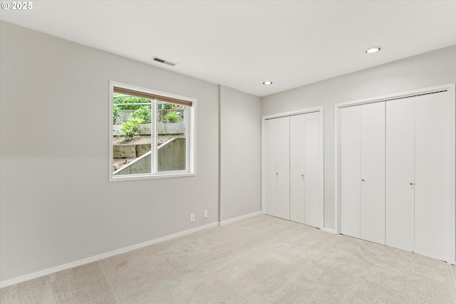 48 Eagle Crest Dr Unit 3D, Lake Oswego, OR 97035 - unfurnished bedroom featuring multiple closets, carpet flooring, and recessed lighting
