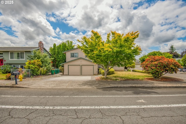 642 SW Cherry Park Rd, Troutdale, OR 97060 - obstructed view of property featuring a garage, concrete driveway, a chimney, and a front yard