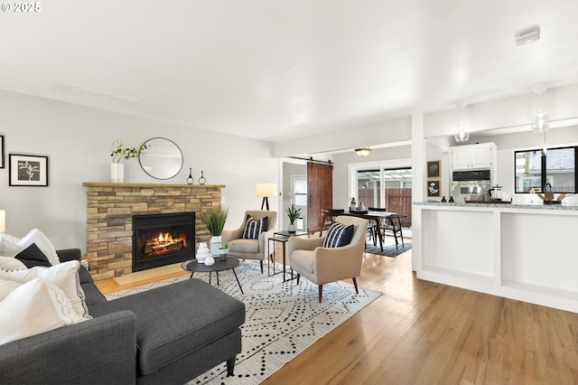 2338 NE 137th Ave, Portland, OR 97230 - living area featuring a barn door, light wood-type flooring, and a fireplace