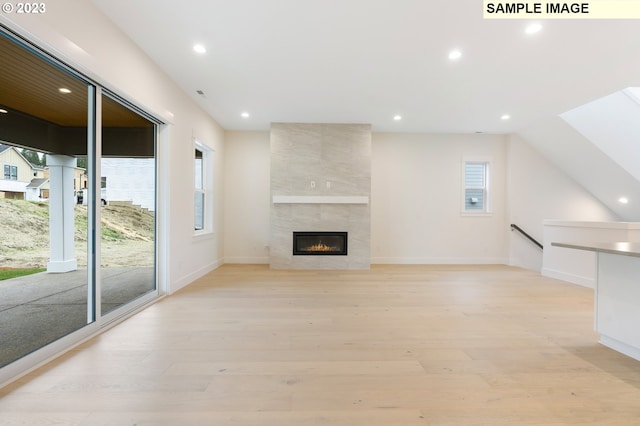 unfurnished living room featuring a fireplace and light hardwood / wood-style floors