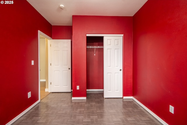 unfurnished bedroom with a closet and baseboards