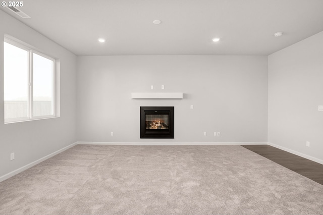 5954 Henshaw St SE, Albany, OR 97322 - unfurnished living room with carpet floors, a glass covered fireplace, baseboards, and recessed lighting