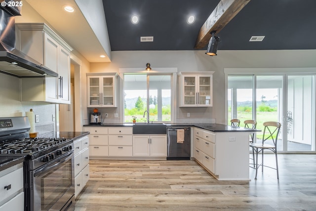 641 E Jones St, Yacolt, WA 98675 - kitchen with stainless steel range with gas cooktop, dishwashing machine, wall chimney exhaust hood, a peninsula, and a sink