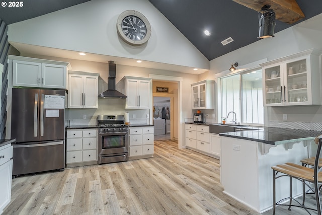 641 E Jones St, Yacolt, WA 98675 - kitchen featuring appliances with stainless steel finishes, wall chimney range hood, washing machine and dryer, a sink, and dark countertops