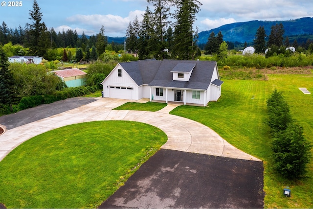 641 E Jones St, Yacolt, WA 98675 - view of front facade with driveway, a front yard, covered porch, a mountain view, and a garage