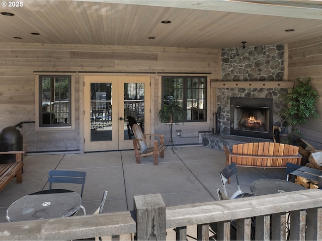 view of patio / terrace featuring an outdoor stone fireplace and french doors
