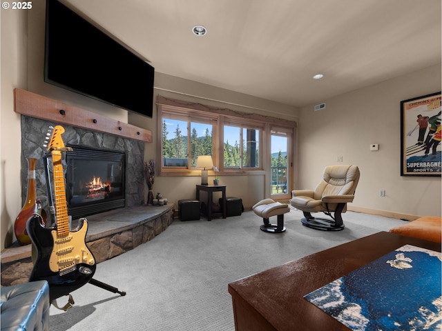 carpeted living room with a stone fireplace and recessed lighting