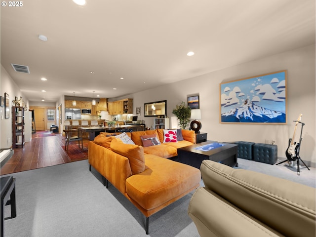 living area with recessed lighting, dark carpet, and dark wood-style flooring