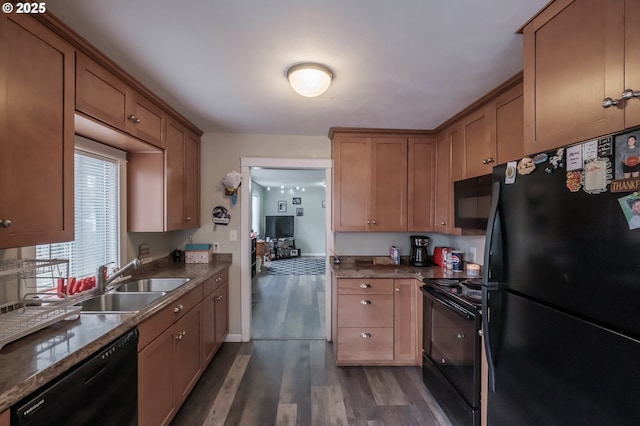 kitchen featuring dark wood-style floors, black appliances, and a sink