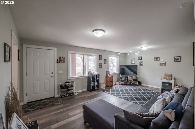 living area with baseboards and dark wood-style flooring