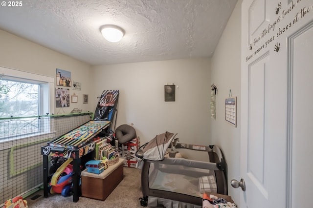 recreation room featuring carpet floors and a textured ceiling