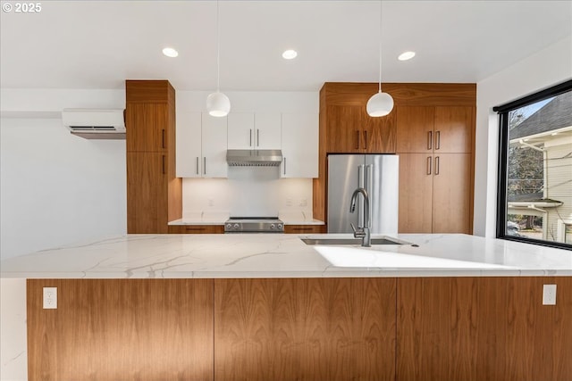 kitchen featuring under cabinet range hood, white cabinetry, decorative light fixtures, and modern cabinets