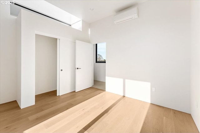 interior space with a wall unit AC, a closet, and wood finished floors