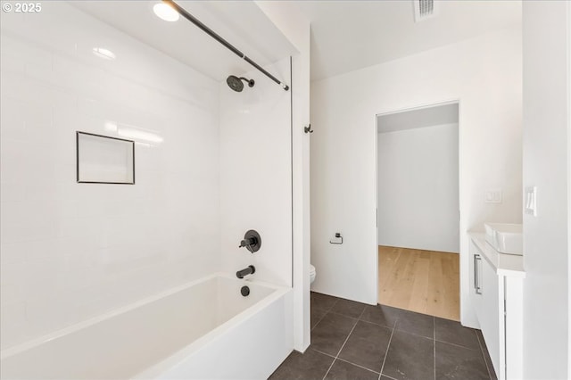 full bath featuring tile patterned flooring, toilet, vanity, visible vents, and washtub / shower combination