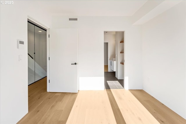 unfurnished room featuring visible vents and wood finished floors