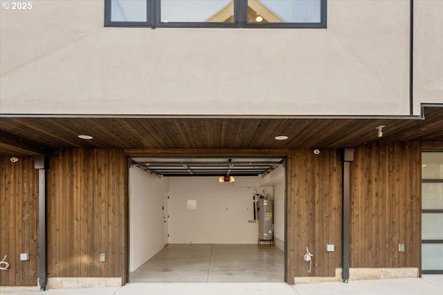 interior space with wooden ceiling, water heater, and wooden walls