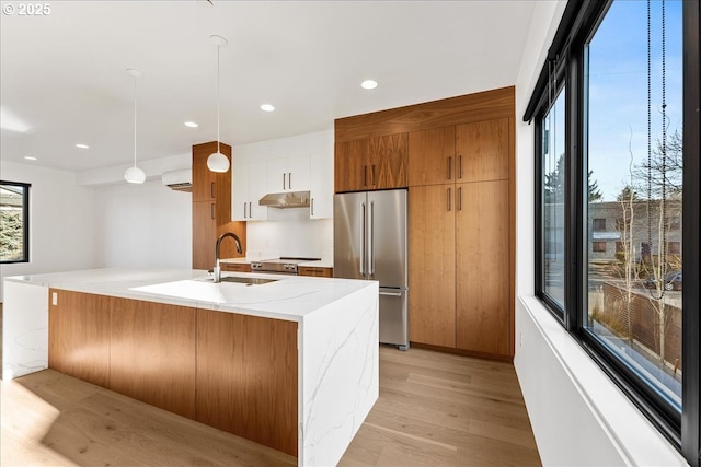 kitchen featuring decorative light fixtures, appliances with stainless steel finishes, a kitchen island with sink, white cabinets, and modern cabinets