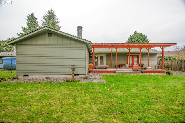 rear view of property with a yard, a wooden deck, and french doors