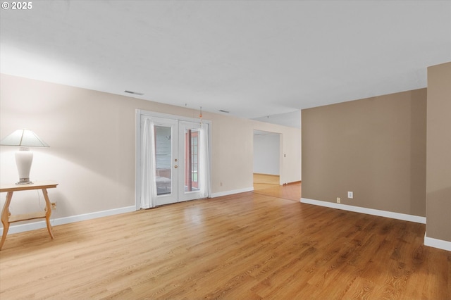 unfurnished room with hardwood / wood-style flooring and french doors