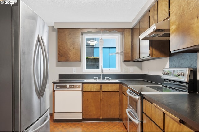 kitchen featuring a textured ceiling, sink, stainless steel appliances, and exhaust hood