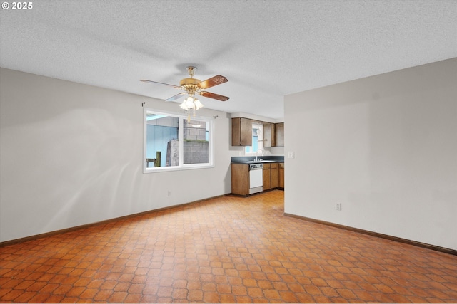 unfurnished living room featuring ceiling fan, sink, and a textured ceiling