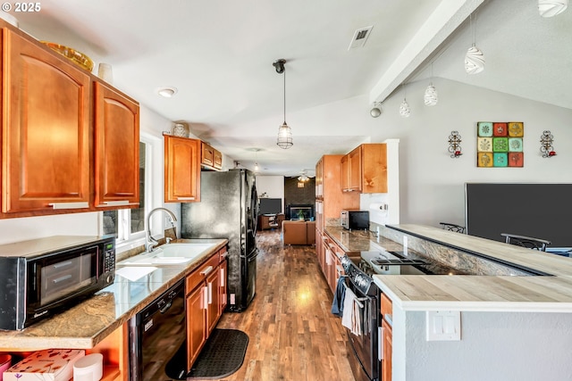 kitchen featuring vaulted ceiling with beams, wood finished floors, a sink, black appliances, and pendant lighting