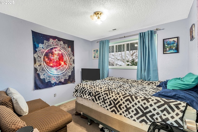 carpeted bedroom with baseboards, visible vents, and a textured ceiling