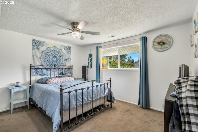 bedroom with ceiling fan, a textured ceiling, visible vents, baseboards, and carpet