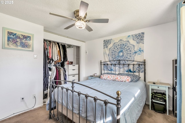 carpeted bedroom with ceiling fan, a textured ceiling, and a closet