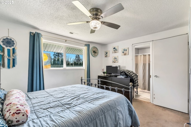 carpeted bedroom with a textured ceiling, ceiling fan, and visible vents