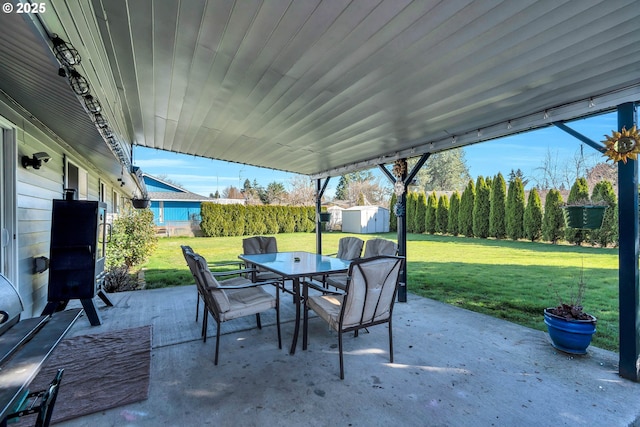 view of patio with outdoor dining area, a fenced backyard, an outdoor structure, and a storage unit