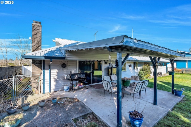 view of patio with fence and a grill