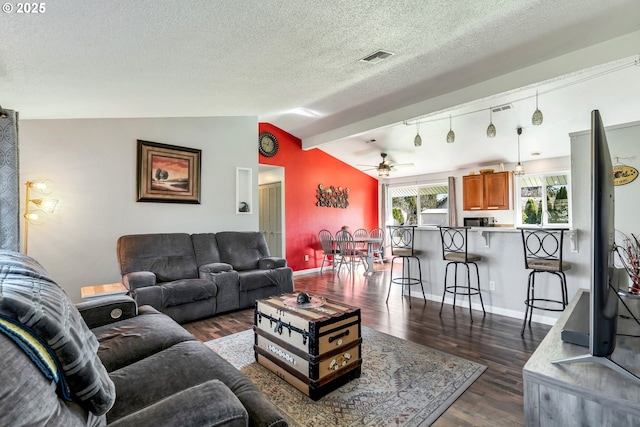 living area featuring visible vents, baseboards, lofted ceiling, dark wood-style floors, and a textured ceiling