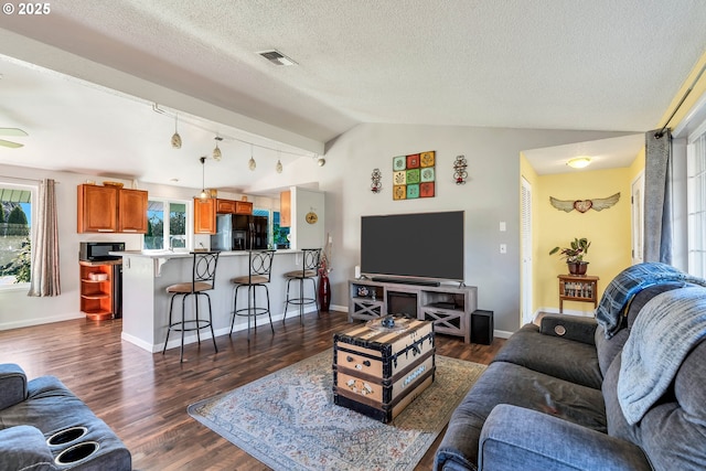 living room with baseboards, visible vents, lofted ceiling, dark wood-style floors, and a textured ceiling