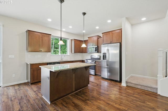 10090 NW Bartlett Loop, North Plains, OR 97133 - kitchen featuring appliances with stainless steel finishes, dark wood finished floors, a center island, backsplash, and hanging light fixtures