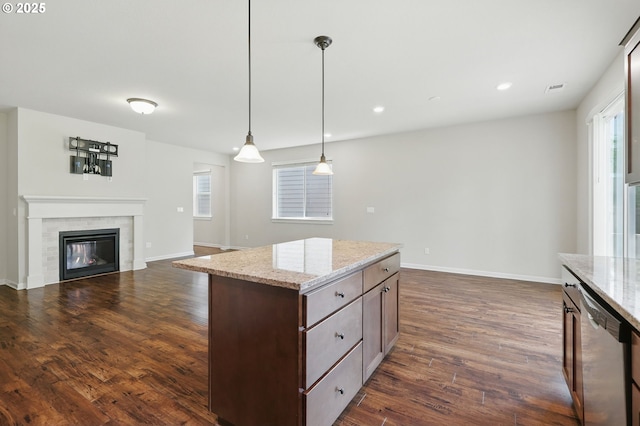 10090 NW Bartlett Loop, North Plains, OR 97133 - kitchen with stainless steel dishwasher, dark wood finished floors, pendant lighting, a tile fireplace, and light stone countertops