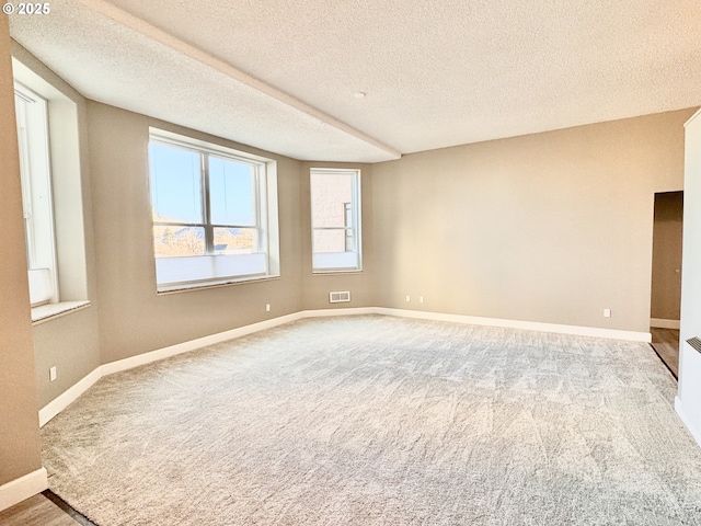 carpeted spare room featuring a textured ceiling