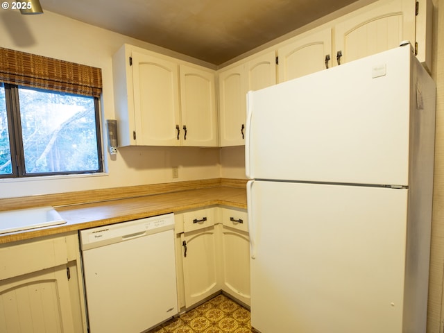 kitchen featuring white cabinetry, white appliances, and sink