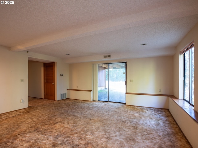 carpeted empty room featuring a textured ceiling