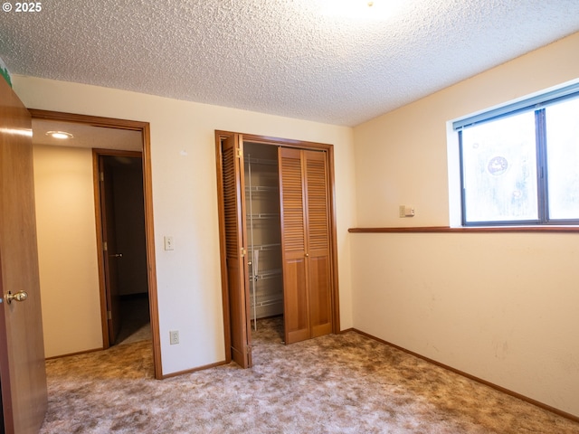 unfurnished bedroom featuring light colored carpet, a closet, and a textured ceiling