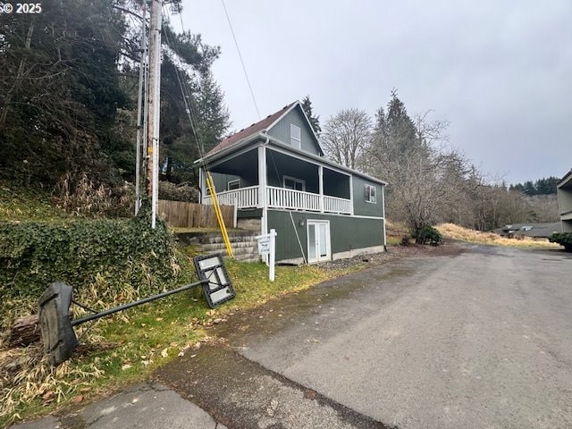 view of front of property featuring driveway and fence