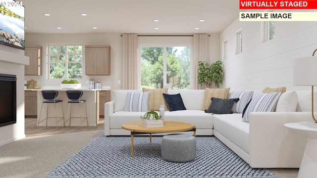 living room featuring recessed lighting, light colored carpet, a wealth of natural light, and a fireplace