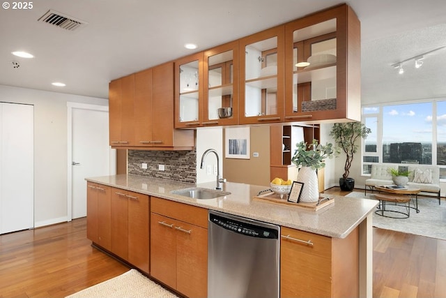 1500 SW 11th Ave Unit 2404, Portland, OR 97201 - kitchen featuring stainless steel dishwasher, a sink, wood finished floors, light stone countertops, and recessed lighting