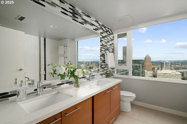 1500 SW 11th Ave Unit 2404, Portland, OR 97201 - bathroom featuring a view of city, toilet, double vanity, and tile patterned flooring