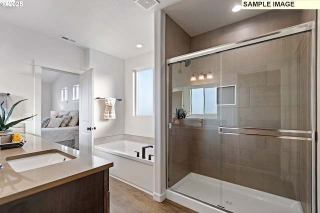 bathroom featuring hardwood / wood-style floors, vanity, and independent shower and bath