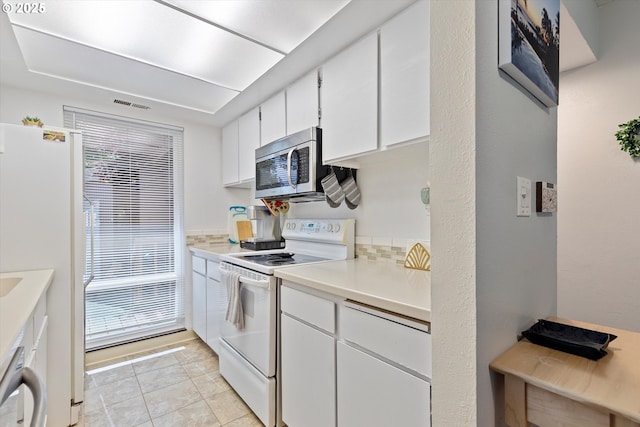 1735 NW Lakeway Ln, Beaverton, OR 97006 - kitchen featuring white appliances, white cabinets, light countertops, light tile patterned floors, and tasteful backsplash