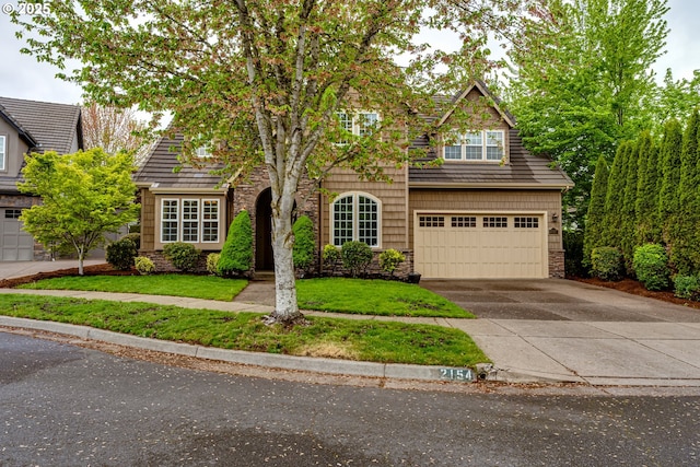 view of front facade featuring an attached garage, a front lawn, stone siding, and concrete driveway