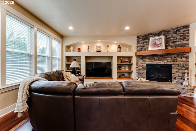 living area with a fireplace, built in features, recessed lighting, baseboards, and dark wood-style floors