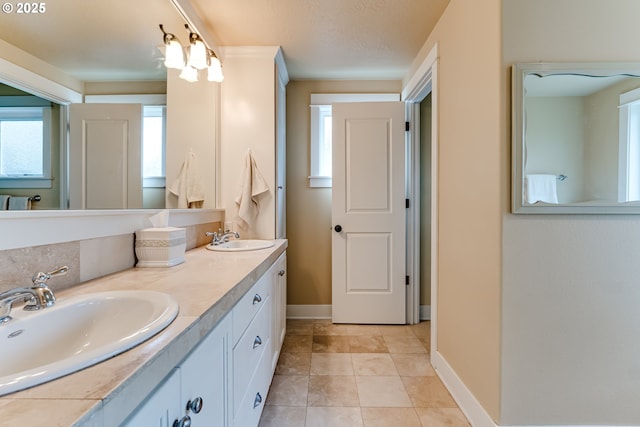 full bathroom featuring a sink, baseboards, tile patterned flooring, and double vanity